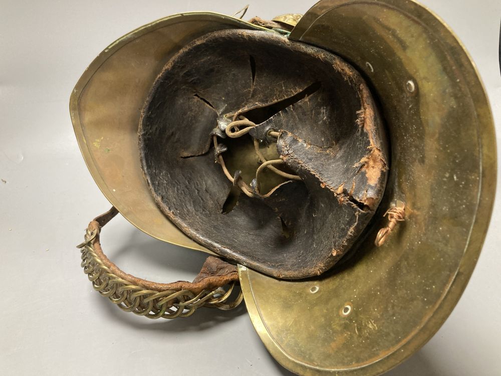 An early 20th century brass firemans helmet, 17cm